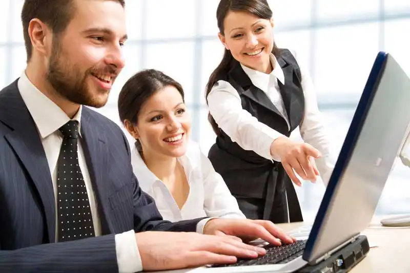 Three people looking at a computer showing enterprise document management software