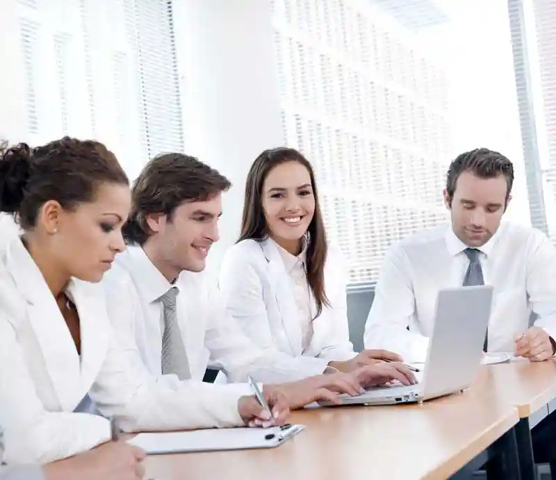 Employees around a computer looking at Document Management software