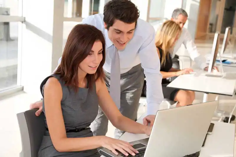 Woman and man looking at a computer screen showing document management software