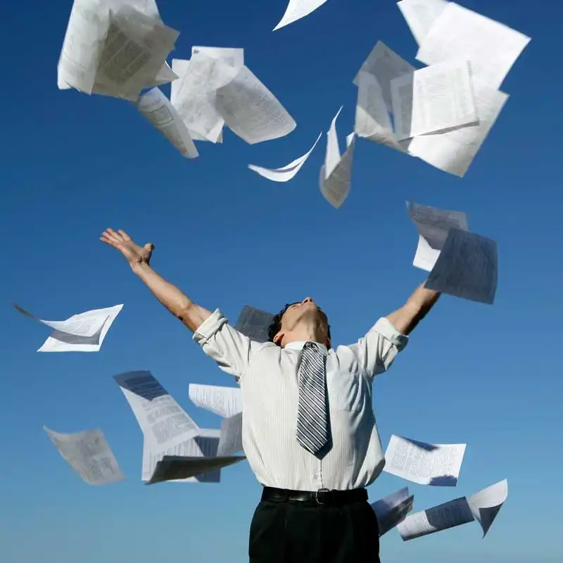 Man throwing papers into the air representing paperless forms