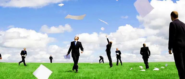 Man chasing papers in open field